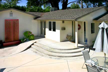Courtyard with wheelchair ramp and double-doors into office/or/ third bedroom. Main entrance with wreath